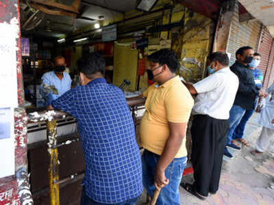 People buy liquor from a wine shop at Shiv Puri in Delhi (file photo)