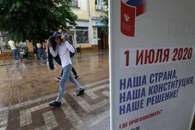 A teenager walks past a board advertising a nationwide vote on constitutional changes in Simferopol, Crimea June 16, 2020 (Reuters)