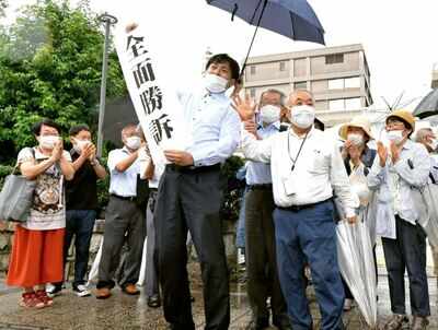 A group of supporters for plaintiffs celebrate, holding a banner which reads "Overall victory" outside the Hiroshima district court in Hiroshima, western Japan, Wednesday, July 29, 2020. A court has recognized people exposed to radioactive “black rain” that fell after the U.S. atomic attack on Hiroshima as atomic bomb survivors, ordering the government to provide the same medical benefits it gives other survivors. (AP)