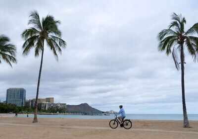 Hurricane Isaias ripped shingles off roofs and blew over trees as it carved its way through the Bahamas early Saturday and headed toward the Florida coast, where officials in Miami said they were closing beaches, marinas and parks.