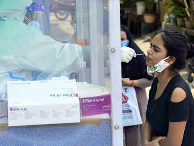 A medic collects sample from a woman for Covid-19 test in Delhi