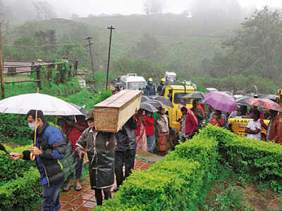 Rescue workers carry bodies after postmortem examination
