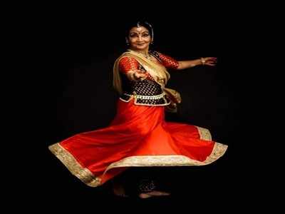 Kathak dancer sitting gracefully on the floor and performing. - SuperStock