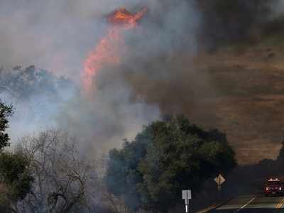 Wind fans wildfire in California canyons, residents flee