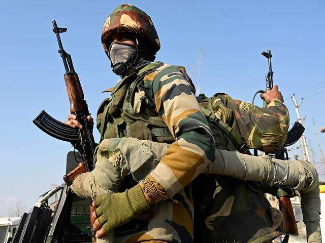 Indian army soldiers stand guard during a gunbattle in Lawaypora area on the outskirts of Srinagar on December 30, 2020 Indian army soldiers stand guard during a gunbattle in Lawaypora area on the outskirts of Srinagar on December 30, 2020