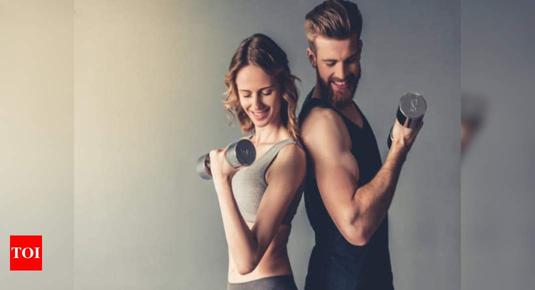 Couple Doing Weights Workout At Home