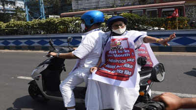 West Bengal CM Mamata Banerjee rides pillion on an e-scooter to protest rising fuel prices