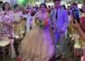 Wedding planner hides under bride's gown to help her walk amid the strong winds