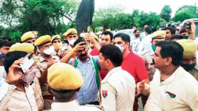 Local Congress leader Pramod Sharma holds a black flag while the police and BJP workers persuade him to call off the protest