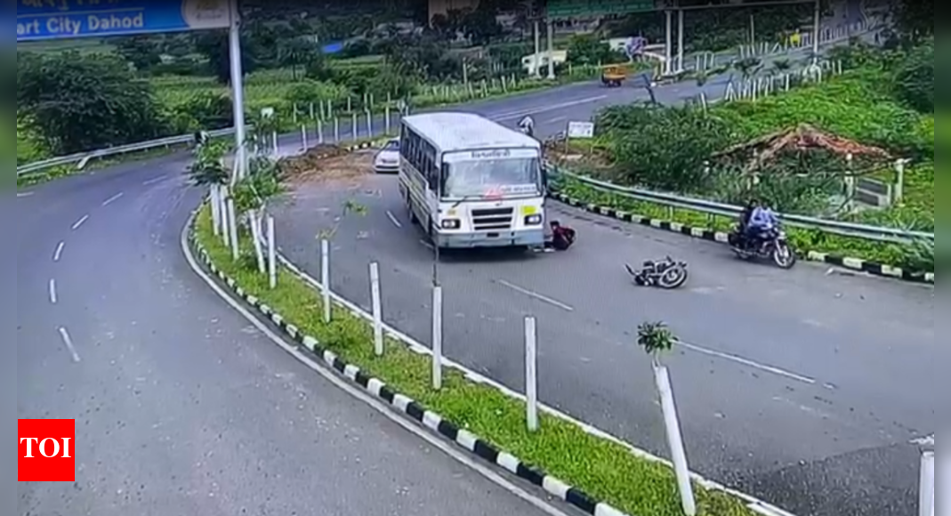 Gujarat: Motorcyclist escapes unhurt after getting trapped under bus in ...