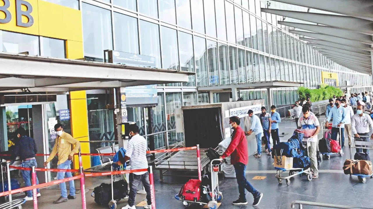 Passengers wait next to a giant suitcase outside the terminal building of  Bengaluru International Airport at its opening in Devanahalli, on the  outskirts of Bangalore, India, Friday, May 23, 2008. The Bengaluru