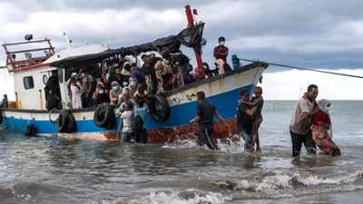 Indonesia navy ship tows boat with Rohingya refugees to port