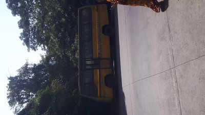 People urinating behind the parked school bus.
