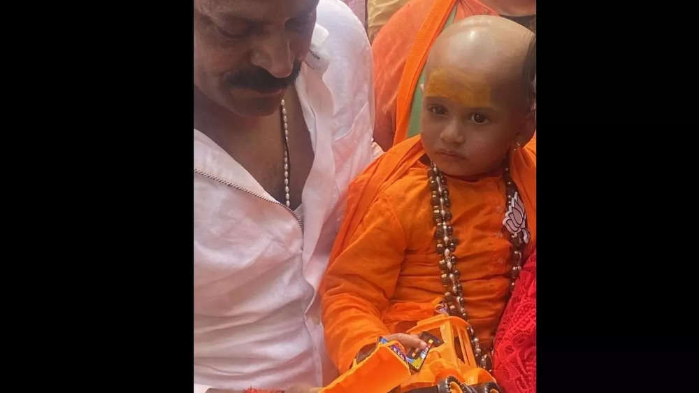 A 1.5-year-old child, Navya dresses up as CM Yogi Adityanath and carries a toy bulldozer, as she arrives at BJP office in Lucknow along with her father.