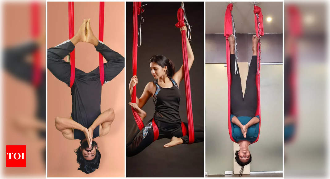 Premium Photo | Two young women doing a butterfly pose in aerial yoga