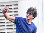 SRK flaunted his chiselled body as he wore a blue T-shirt and denim pants with a pair of sunglasses.