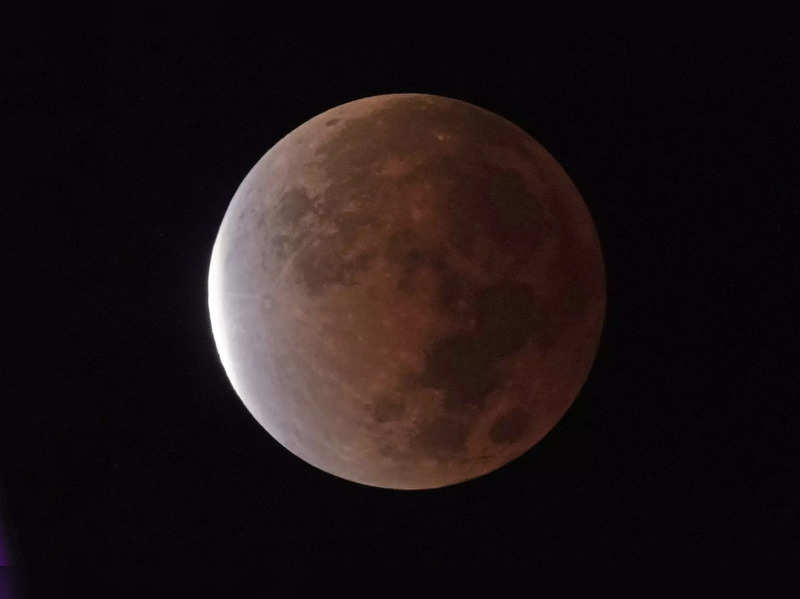 FILE - The earth's shadow covers the full moon during a partial lunar eclipse, Friday, Nov. 19, 2021, in Kansas City, Mo.  A total lunar eclipse will grace the night skies this weekend, providing longer than usual thrills for stargazers across North and South America. The celestial action unfolds Sunday, May 15, 2022 night into early Monday morning, with the moon bathed in the reflected red and orange hues of Earth’s sunsets and sunrises for about 1 1/2 hours, the longest totality of the decade. It will be the first so-called blood moon in a year.(AP Photo/Charlie Riedel, File)