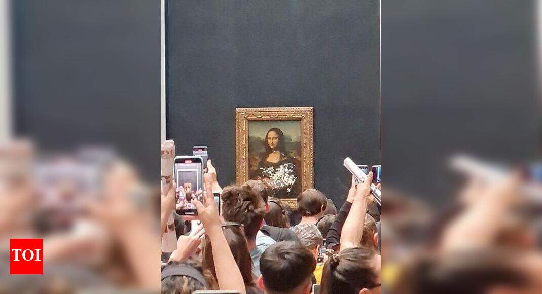 Man dressed as an old woman throws cake at Mona Lisa portrait Times