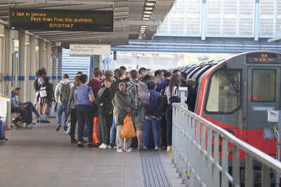 Passengers board a tube at Stratford station, as train services continue to be disrupted following the nationwide strike by members of the Rail, Maritime and Transport union, along with London Underground workers, in London, Wednesday. (File photo: AP) banner img
