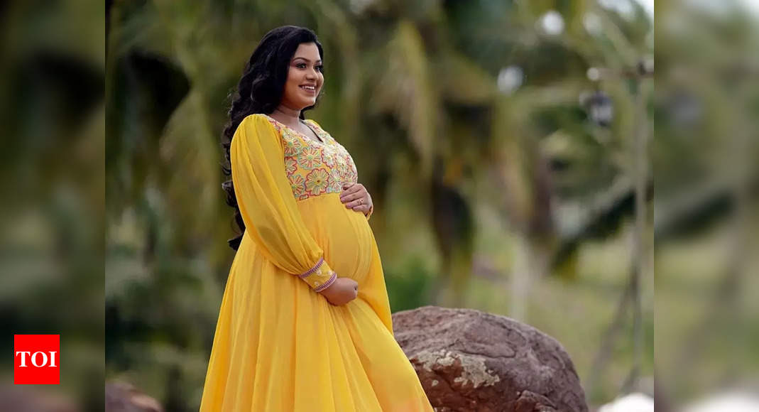 Indian young pregnant woman posing in a sari in the room, Mumbai