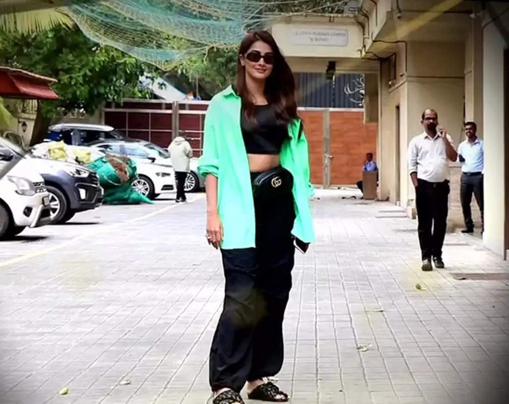
Pooja Hegde dons black-coloured crop top paired with green-coloured shirt, completes her overall look with black joggers
