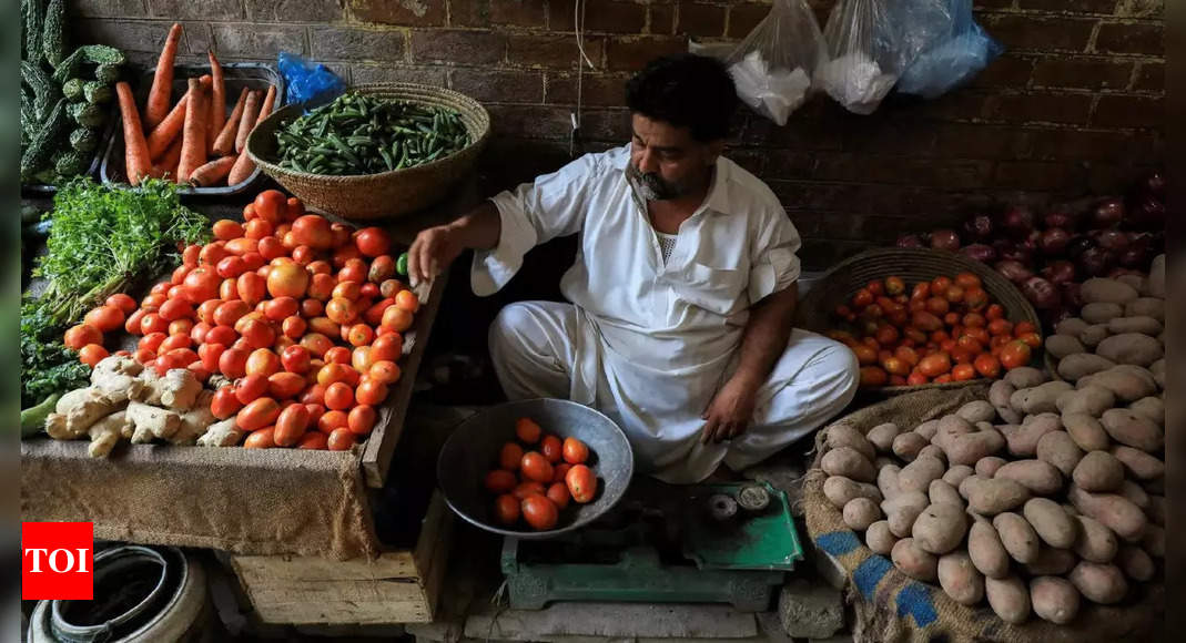 Pakistani shoppers purchase vegetables from a stall inside a