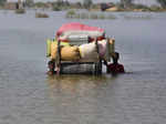 Flood-affected people use cot to salvage belongings from their nearby flooded ho...