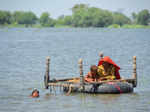 FILE PHOTO: Flood victims use an inflatable tube as they travel in flood waters, following rains and floods during the monsoon season, in Dera Allah Yar