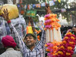 New Delhi: A vendor selling plastic flowers waits for customers at a crowded Sad...