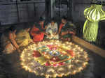 Nagpur: Women decorate a 'rangoli' with earthen lamps on the occasion of Diwali,...