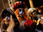 People wear costumes celebrating Halloween in front of a closed bar at Lan Kwai Fong in Hong Kong