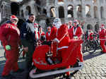 People dressed in Santa Claus costumes ride on bicycles through the streets of Rome