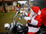 Helton Garcia dressed as Santa Claus rides on a motorcycle before distributing small presents to children in a rural school in Santo Antonio do Descoberto, state of Goias