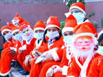 New Delhi: Students dressed as Santa Claus wearing a mask taking Covid-19 precautions celebrate Christmas at Vidya Bal Bhawan school of Mayur Vihar in New Delhi, Friday, Dec. 23, 2022. (Photo: IANS)