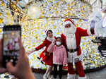 A child poses with a performer dressed as Santa Claus during a Christmas lighting ceremony at a shopping mall in Hong Kong