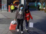 A woman and a child walk in a shopping district as China returns to work despite continuing coronavirus disease (COVID-19) outbreaks in Beijing