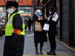 Women with shopping bags stand in a street as China returns to work despite continuing coronavirus disease (COVID-19) outbreaks in Beijing