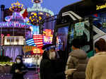 A staff wearing a protective mask and a face shield guides people get on a shuttle bus at Grand Lisboa casino, in Macau