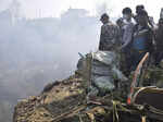 Nepalese rescue workers and civilians gather around the wreckage of a passenger ...