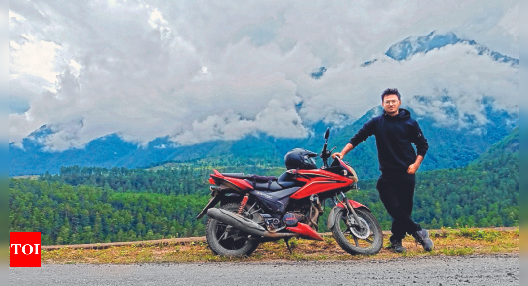 Indian man posed next to a Pulsar motorbike