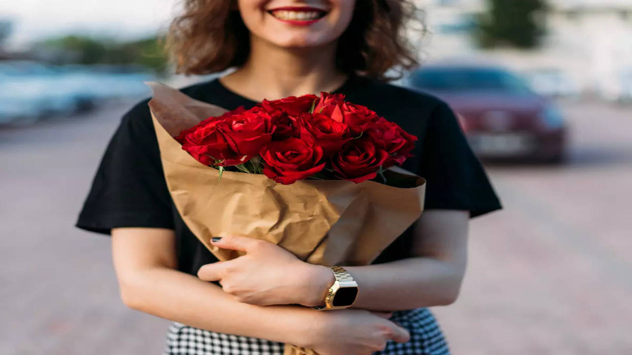 Perfect gift. Wonderful flowers on Womens Day. Tender smiling brunet woman  poses with big bouquet of roses, looks happily, isolated over blue studio  background. full-length portrait Stock Photo | Adobe Stock