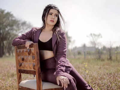 Young woman in modish suit with leopard belt bag posing at a grey  background, isolated. Beautiful model girl in formal clothes and with  trendy belt bag with leopard pattern. Spring fashion Stock