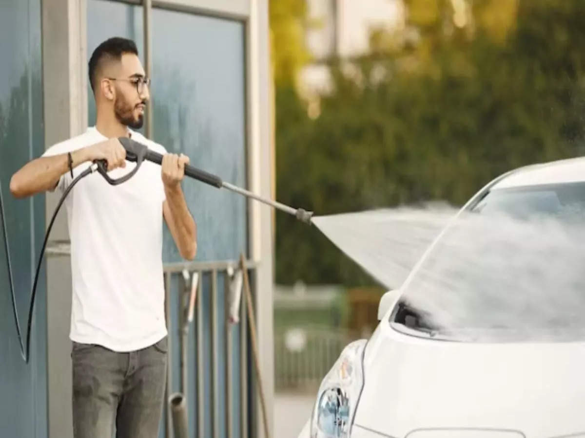 Man Washing His Car With A High Pressure Hose With A Fine Mist