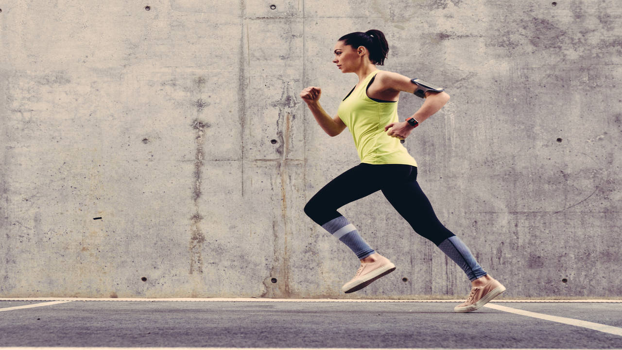 Foto de Fitness trained female stretching arms behind back, doing warm up  exercises. Woman runner with fit body do workout before jogging in  sportswear, white background do Stock