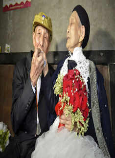 Yan Zhengming (L), 94, kisses the hand of his wife Zhou Suqing- Photogallery  - Times of India