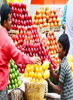 A boy helps his father in arranging fruits at their Photogallery - Times of India