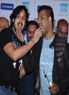 Krishna Ajai Rao and Sathish Neenasam feed each other cake at the audio launch of Rocket