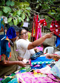 A woman purchases bags and accessories during an event
