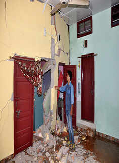 A man showing the cracks in his house