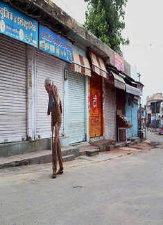 An old man walks past closed shops